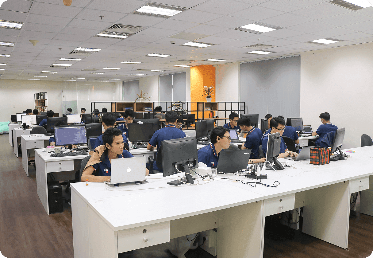 Team of employees working on computers in a modern open office environment.