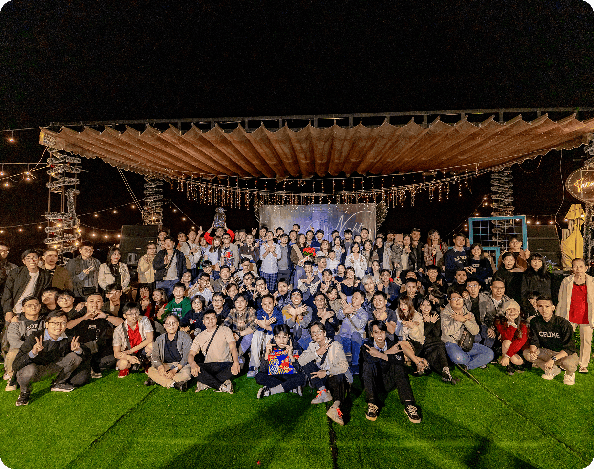 A group of employees enjoying a team lunch outdoors on a sunny day.