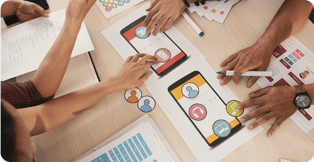 People designing a mobile app user interface on paper