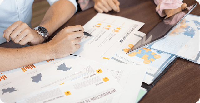 Close-up of people reviewing business reports and maps