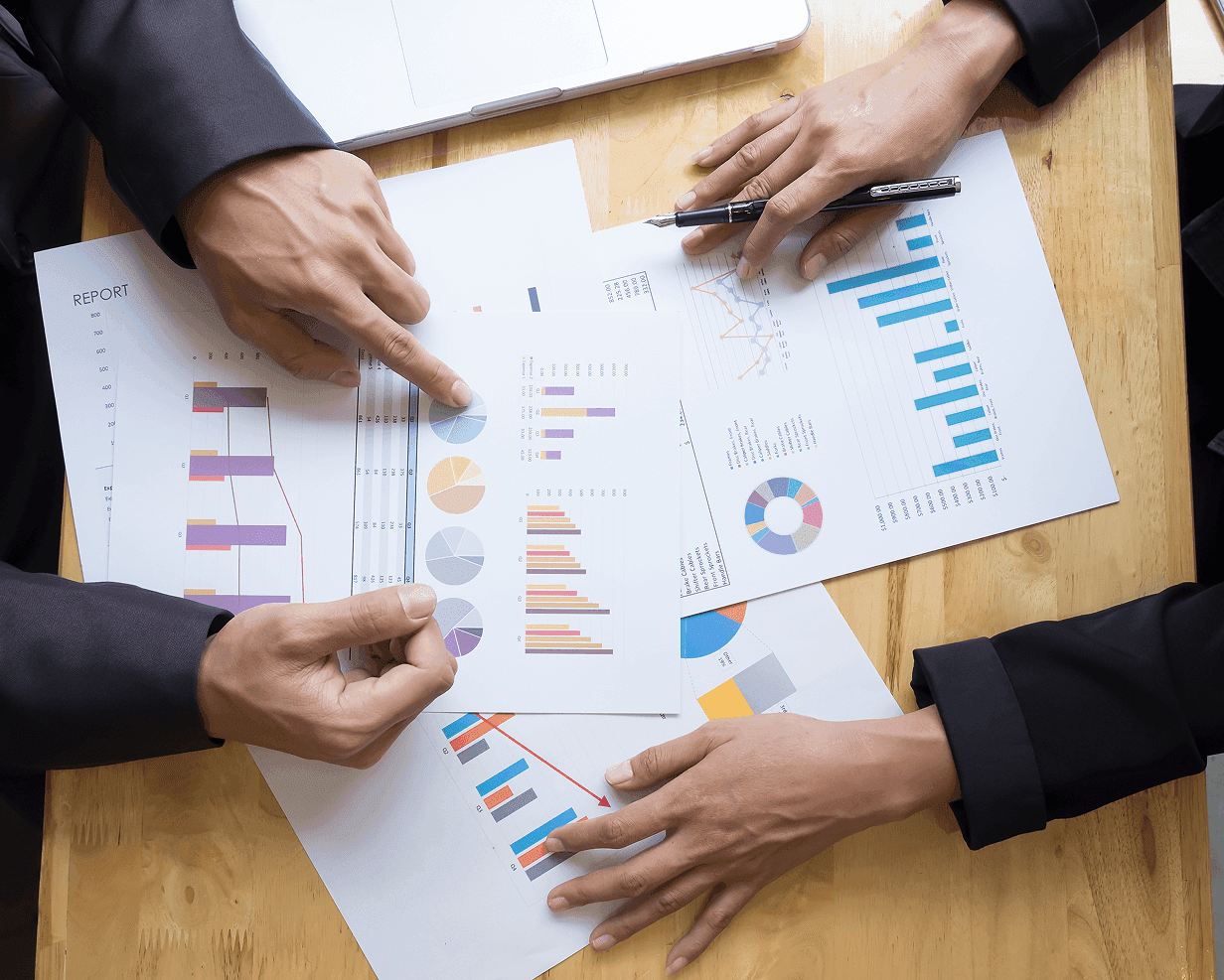 Overhead view of two people analyzing paper business charts