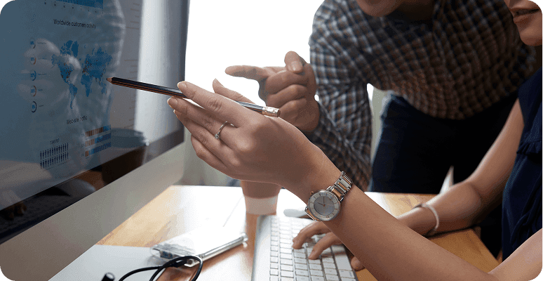 Team analyzing data and charts on a computer monitor