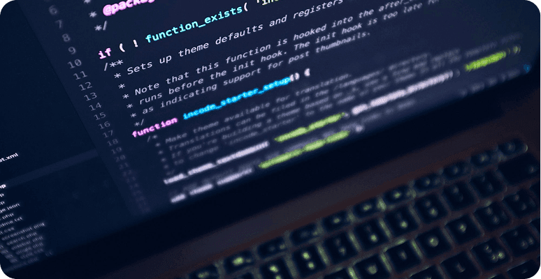 Code displayed on a dark computer screen and keyboard