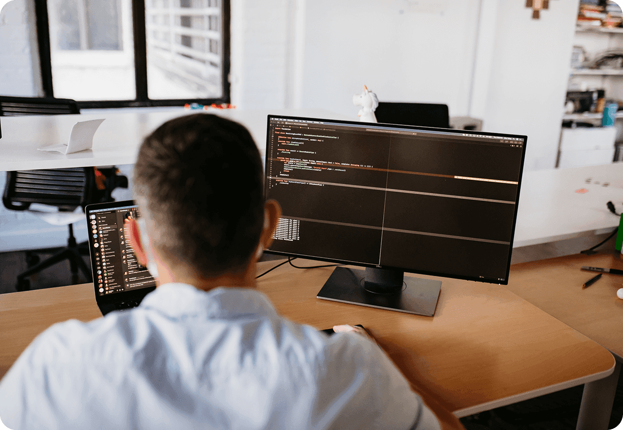 Developer looking at code on a large monitor
