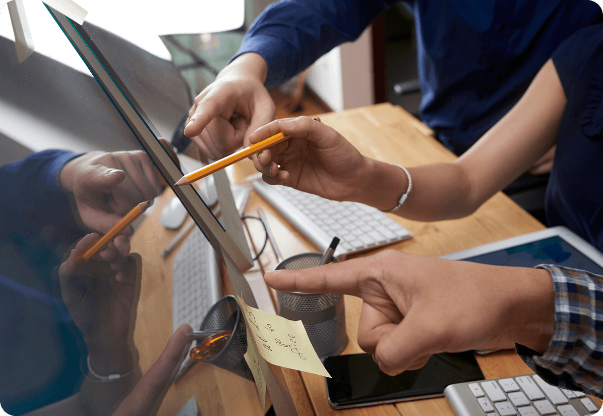 Colleagues pointing at a computer screen during a discussion