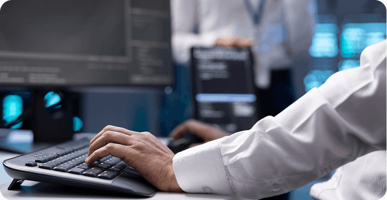 IT specialist typing on keyboard in monitoring room