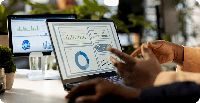 Person using a laptop displaying business analytics dashboard with charts and graphs.