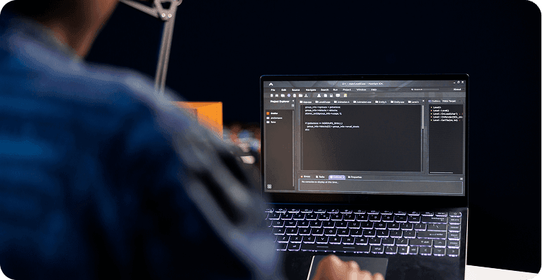 Person coding on a laptop in a dark setting