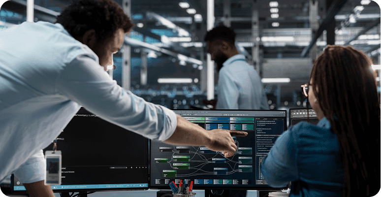 Developers collaborating in front of computer screens.